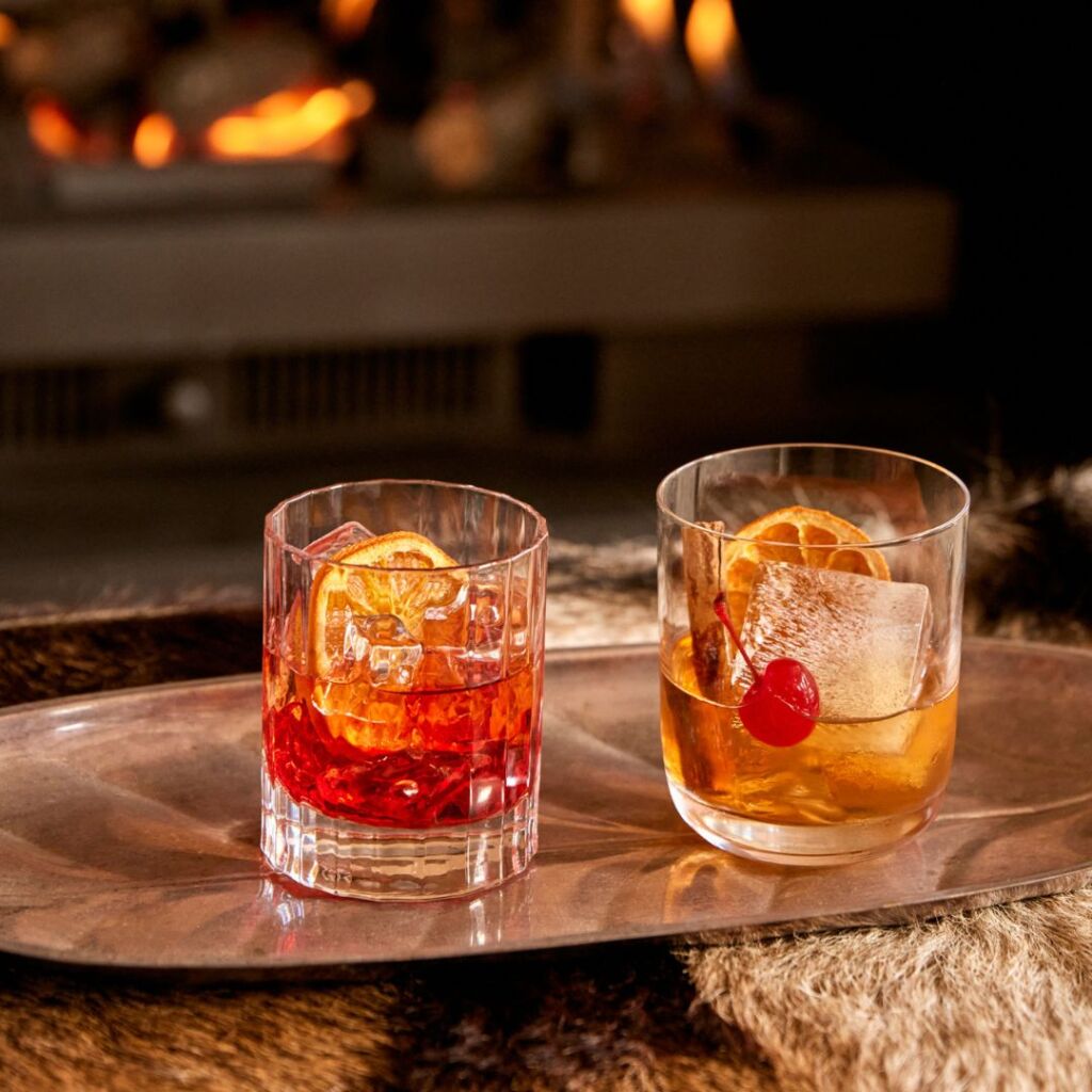 Après-ski cocktails served by a warm fireplace at The Stables Resort Perisher.