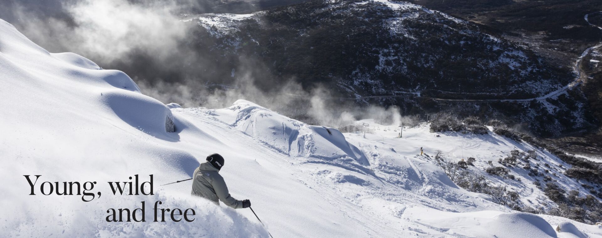 Skier carving through fresh powder on a snow-covered slope at Perisher Ski Resort, overlooking the Snowy Mountains, featured in the Vacations & Travel magazine article "Young, Wild and Free".